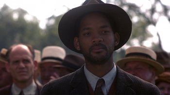 Movie still from “The Legend of Bagger Vance” (2000), directed by Robert Redford – A person wearing a suit and a hat; Close Up shot, Over the shoulder angle