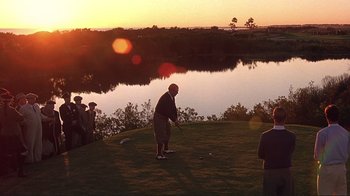 Movie still from “The Legend of Bagger Vance” (2000), directed by Robert Redford – A group of people standing on top of a grass covered field; Extreme Wide shot, Over the shoulder angle
