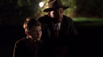 Movie still from “The Legend of Bagger Vance” (2000), directed by Robert Redford – A man and a boy sitting in the dark; Close Up shot, Over the shoulder angle