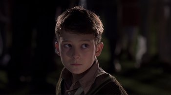 Movie still from “The Legend of Bagger Vance” (2000), directed by Robert Redford – A young boy is looking into the camera; Close Up shot, High angle