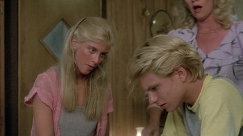 Movie still from “The Legend of Billie Jean” (1985), directed by Matthew Robbins – A woman standing next to a man in a room; Close Up shot, Over the shoulder angle