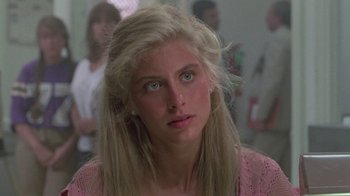 Movie still from “The Legend of Billie Jean” (1985), directed by Matthew Robbins – A woman with long blonde hair wearing a pink sweater; Close Up shot, Over the shoulder angle
