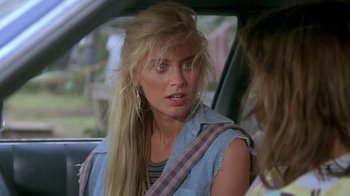 Movie still from “The Legend of Billie Jean” (1985), directed by Matthew Robbins – A young woman sitting in the back seat of a car; Close Up shot, Over the shoulder angle