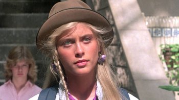 Movie still from “The Legend of Billie Jean” (1985), directed by Matthew Robbins – A woman wearing a hat and a necklace; Close Up shot, High angle