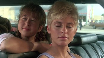Movie still from “The Legend of Billie Jean” (1985), directed by Matthew Robbins – Two young girls sitting in the back seat of a car; Close Up shot, Low angle