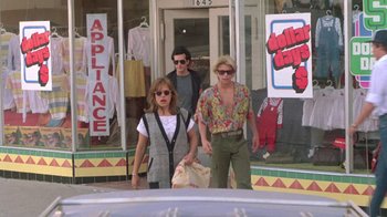 Movie still from “The Legend of Billie Jean” (1985), directed by Matthew Robbins – A group of people walking down a street; Wide shot, Low angle