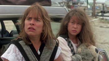Movie still from “The Legend of Billie Jean” (1985), directed by Matthew Robbins – Two young women sitting next to each other in front of a car; Close Up shot, Low angle