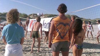 Movie still from “The Legend of Billie Jean” (1985), directed by Matthew Robbins – A group of young people playing volleyball on the beach; Wide shot, Over the shoulder angle