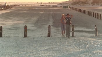 Movie still from “The Legend of Billie Jean” (1985), directed by Matthew Robbins – A man and a woman standing on the side of a road; Wide shot, High angle