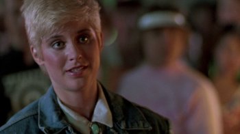 Movie still from “The Legend of Billie Jean” (1985), directed by Matthew Robbins – A person with short blonde hair; Close Up shot, Over the shoulder angle