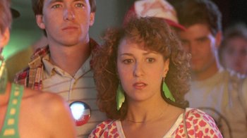 Movie still from “The Legend of Billie Jean” (1985), directed by Matthew Robbins – A woman with curly red hair is standing next to a man; Close Up shot, Over the shoulder angle