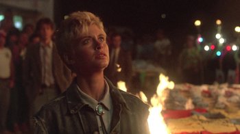 Movie still from “The Legend of Billie Jean” (1985), directed by Matthew Robbins – A woman standing in front of a fire pit; Close Up shot, Low angle