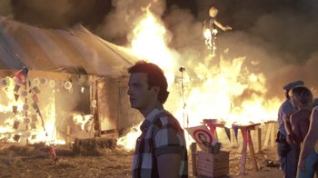 Movie still from “The Legend of Billie Jean” (1985), directed by Matthew Robbins – A man standing in front of a burning building; Wide shot, Low angle