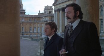 Movie still from “The Legend of Hell House” (1973), directed by John Hough – A couple of men standing next to each other; Medium shot, Low angle