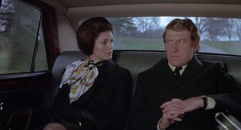 Movie still from “The Legend of Hell House” (1973), directed by John Hough – A man and a woman sitting in the back of a car; Medium shot, Low angle