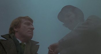 Movie still from “The Legend of Hell House” (1973), directed by John Hough – Two men are smoking a cigarette in the fog; Medium shot, Over the shoulder angle
