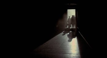 Movie still from “The Legend of Hell House” (1973), directed by John Hough – A group of people standing in a hallway; Extreme Wide shot, Low angle