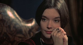 Movie still from “The Legend of Hell House” (1973), directed by John Hough – A young woman holding a cat's paw in front of her face; Close Up shot, High angle