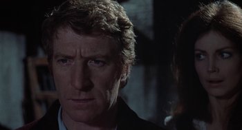 Movie still from “The Legend of Hell House” (1973), directed by John Hough – A person wearing a suit and tie; Close Up shot, Over the shoulder angle