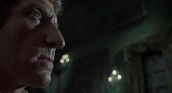 Movie still from “The Legend of Hell House” (1973), directed by John Hough – A man's face in a dark room; Close Up shot, Low angle
