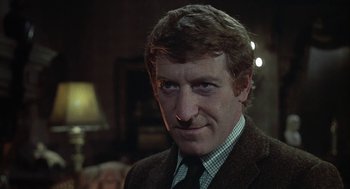 Movie still from “The Legend of Hell House” (1973), directed by John Hough – A person wearing a suit and tie; Close Up shot, Low angle