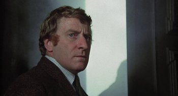 Movie still from “The Legend of Hell House” (1973), directed by John Hough – A person wearing a suit and tie; Close Up shot, Low angle