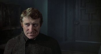 Movie still from “The Legend of Hell House” (1973), directed by John Hough – A person wearing a jacket; Close Up shot, Over the shoulder angle