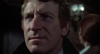 Movie still from “The Legend of Hell House” (1973), directed by John Hough – A man's face in a dark room; Close Up shot, Low angle