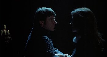 Movie still from “The Legend of Hell House” (1973), directed by John Hough – A man and a woman face to face in the dark; Close Up shot, Low angle