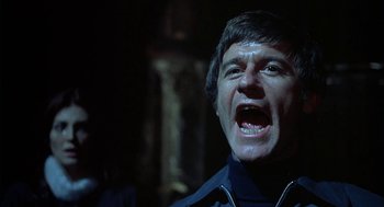 Movie still from “The Legend of Hell House” (1973), directed by John Hough – A man with his mouth wide open in the dark; Close Up shot, Low angle