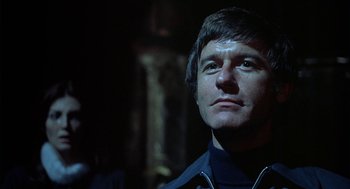 Movie still from “The Legend of Hell House” (1973), directed by John Hough – A person wearing a black jacket; Close Up shot, Low angle