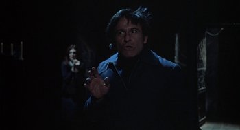 Movie still from “The Legend of Hell House” (1973), directed by John Hough – A man and a woman in a dark room; Medium shot, Low angle