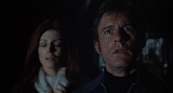 Movie still from “The Legend of Hell House” (1973), directed by John Hough – A man and a woman looking at something in the dark; Close Up shot, Low angle