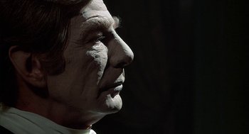 Movie still from “The Legend of Hell House” (1973), directed by John Hough – A person's face with makeup on it; Close Up shot, Over the shoulder angle