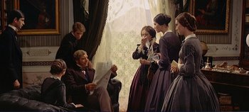 Movie still from “The Leopard” (1963), directed by Luchino Visconti – A group of people standing in a room with a man reading a newspaper; Medium shot, Over the shoulder angle