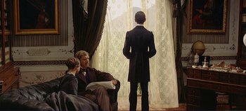 Movie still from “The Leopard” (1963), directed by Luchino Visconti – A man in a black suit standing in front of a window; Wide shot, Over the shoulder angle