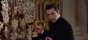 Movie still from “The Leopard” (1963), directed by Luchino Visconti – A man sitting in front of a candle in a room; Close Up shot, Low angle