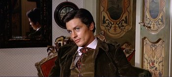 Movie still from “The Leopard” (1963), directed by Luchino Visconti – A man sitting in a chair wearing a suit and tie; Close Up shot, High angle
