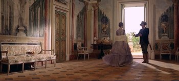 Movie still from “The Leopard” (1963), directed by Luchino Visconti – A woman in an old - fashioned dress walks through an ornate room; Wide shot, Low angle