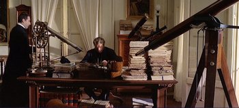 Movie still from “The Leopard” (1963), directed by Luchino Visconti – An old man sitting at a desk with a lot of books; Wide shot, High angle