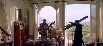 Movie still from “The Leopard” (1963), directed by Luchino Visconti – A man sitting in front of a window looking out at a city; Wide shot, Over the shoulder angle