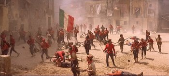 Movie still from “The Leopard” (1963), directed by Luchino Visconti – A group of men in red and white shirts and red hats; Extreme Wide shot, High angle