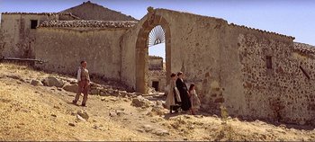 Movie still from “The Leopard” (1963), directed by Luchino Visconti – A group of people standing in front of an old stone building; Extreme Wide shot, Low angle