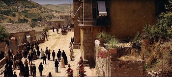 Movie still from “The Leopard” (1963), directed by Luchino Visconti – A group of people standing on the side of a road; Extreme Wide shot, High angle