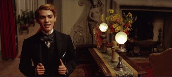 Movie still from “The Leopard” (1963), directed by Luchino Visconti – A man in a suit standing in front of a table; Medium shot, Low angle