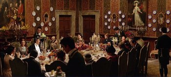 Movie still from “The Leopard” (1963), directed by Luchino Visconti – A group of people sitting around a table with food on top of it; Wide shot, High angle