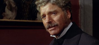 Movie still from “The Leopard” (1963), directed by Luchino Visconti – An older man with a mustache wearing a suit and tie; Close Up shot, Over the shoulder angle