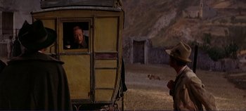 Movie still from “The Leopard” (1963), directed by Luchino Visconti – A man is looking out of the window of an old train car; Medium shot, Over the shoulder angle