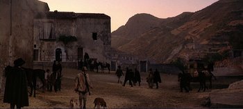 Movie still from “The Leopard” (1963), directed by Luchino Visconti – A group of people walking in a dirt field; Extreme Wide shot, Low angle