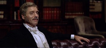 Movie still from “The Leopard” (1963), directed by Luchino Visconti – A man sitting on top of a brown couch; Close Up shot, Low angle